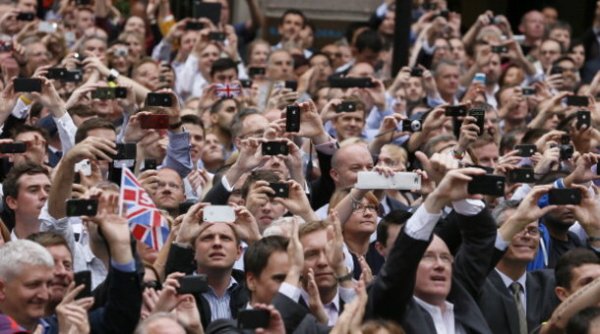 Spectators take pictures with their smartphones as they watch a parade celebrating Britain's athletes who competed in the London 2012 Olympic and Paralympic Games in central London on September 10, 2012. Britain was bidding a fond farewell om September 10 to a golden summer of Olympic and Paralympic sport with a victory parade by athletes through London ending up at Buckingham Palace. AFP PHOTO / POOL / STEFAN WERMUTH        (Photo credit should read STEFAN WERMUTH/AFP/GettyImages)